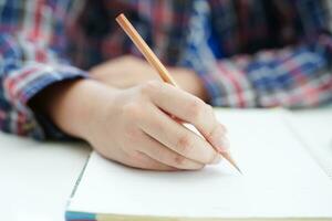 asiatico adolescenziale alunno Scrivi compiti a casa, studia lezione per esame in linea apprendimento formazione scolastica. foto