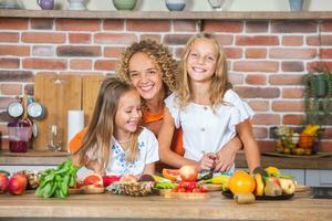 madre e figlie cucinando insieme nel il cucina. salutare cibo concetto. ritratto di contento famiglia con fresco frullati. foto