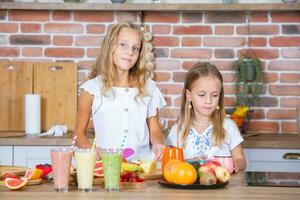 Due poco ragazze nel il cucina con fresco verdure. salutare cibo concetto. contento sorelle. foto