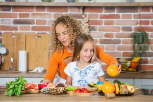 contento madre e figlia siamo avendo divertimento nel il cucina. salutare cibo concetto. foto