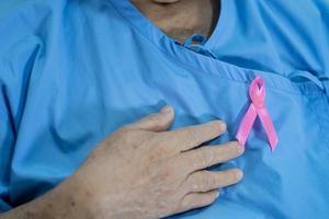 cancro al seno, nastro rosa alla paziente asiatica anziana per sostenere la consapevolezza. foto