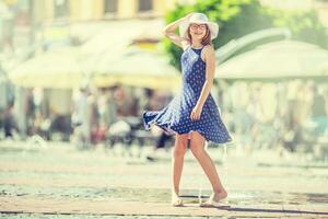 bellissimo carino giovane ragazza danza su il strada a partire dal felicità.carino contento ragazza nel estate Abiti danza nel il sole. foto