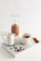 un' grande bianca tazza di delizioso aromatico cappuccino caffè su un' bianca marmo vassoio con cannella bastoni e caffè fagioli. verticale Visualizza. foto
