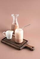 bicchiere di fresco caldo aromatico latte macchiato caffè servito su tavolo foto
