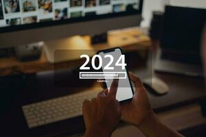 nuovo anno 2024 celebrazione concetto, smartphone e opera scrivania a casa sfondo foto