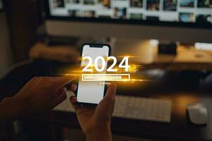 nuovo anno 2024 celebrazione concetto, smartphone e opera scrivania a casa sfondo foto