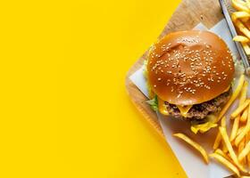 ai generato hamburger e francese patatine fritte con giallo sfondo foto