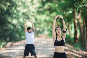 uomo e donna che si allungano insieme al parco. foto