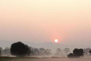 tramonto dietro le montagne nel paesaggio di campagna, thailandia foto