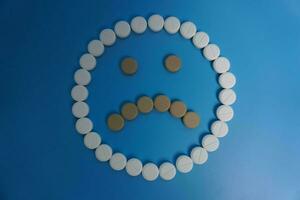 negativo Sorridi fatto di pillole, tavoletta, capsula su blu sfondo. concetto di medicinale, pillole, trattamento, medico assicurazione. triste concetto foto