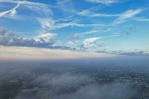 maggior parte bellissimo e migliore alto angolo drammatico colorato cielo metraggio a partire dal sopra il nuvole. il veloce in movimento nuvole durante sole crescente presto nel il mattina al di sopra di luton città di Inghilterra UK foto