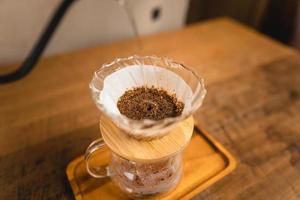 versando acqua calda su un caffè americano foto