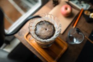 caffè sgocciolato in casa, versando acqua calda sopra un caffè sgocciolato foto