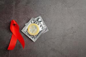 concetto di giornata mondiale della salute del nastro rosso e preservativo foto