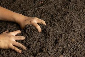 mano che tiene il terreno nero per coltivare il concetto di giornata mondiale del suolo delle colture