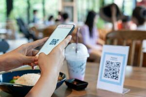 donna uso smartphone per scansione qr codice per ordine menù nel bar ristorante con un' digitale consegna. scegliere menù e ordine accumulare sconto. e portafoglio, tecnologia, pagare in linea, credito carta, banca app. foto