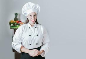 ritratto di un' femmina capocuoco circondato di fresco la verdura, ritratto di un' femmina dietologo nel uniforme con fresco verdure su il tavolo, un' femmina dietologo con un' tavolo di verdure foto