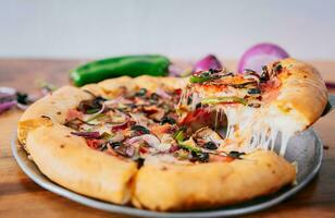 vicino su di spatola assunzione un' fetta di supremo Pizza con verdure. spatola assunzione un' fetta di supremo Pizza con spatola foto