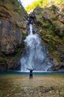 la donna sta davanti alla bellissima cascata. foto