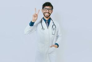 contento medico salutando con Due dita isolato, sorridente medico fabbricazione amore e pace gesto isolato foto