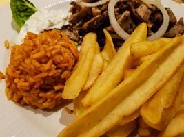 gyros di cibo greco con patatine fritte e insalata foto