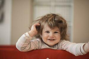 poco bambino ragazza con strano acconciatura e bigodini foto