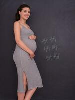ritratto di incinta donna nel davanti di nero lavagna foto