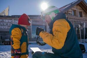 padre preparazione il suo poco figlio per il primo tempo su un' Snowboard foto