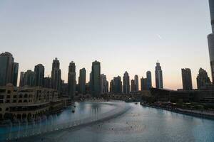 dubai cantando fontane a notte lago Visualizza fra grattacieli. città orizzonte nel crepuscolo moderno architettura nel Emirati Arabi Uniti capitale centro. foto