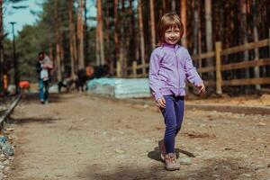 un' poco ragazza giocando nel il parco. il concetto di famiglia socializzazione nel il parco. un' ragazza altalene su un' oscillazione, giochi creativo Giochi foto