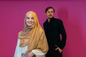 ritratto di contento giovane musulmano coppia in piedi isolato su rosa sfondo foto
