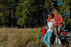 giovane contento eccitato coppia godendo bellissimo soleggiato giorno mentre guida un' via strada passeggino auto su montagna natura foto