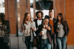 i viaggiatori attività commerciale squadra di colleghi a piedi e parlando su moderno urbano città strade. persone su su di il ufficio su rompere. foto