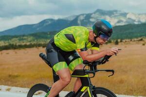 pieno lunghezza ritratto di un attivo triatleta nel abbigliamento sportivo e con un' protettivo casco equitazione un' bicicletta. selettivo messa a fuoco foto