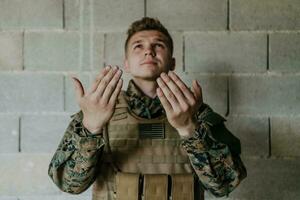un' musulmano soldato di il speciale forze prega per Dio di raccolta il suo mani e inizia un' preghiera foto