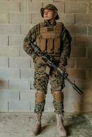 un' soldato nel uniforme sta nel davanti di un' pietra parete nel pieno guerra Ingranaggio preparazione per battaglia foto