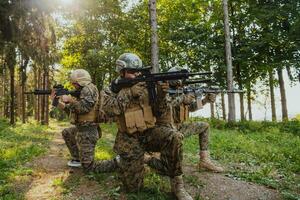 un' gruppo di moderno guerra soldati è combattente un' guerra nel pericoloso a distanza foresta le zone. un' gruppo di soldati è combattente su il nemico linea con moderno Armi. il concetto di guerra e militare conflitti foto