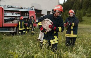 gruppo di fuoco combattenti in piedi fiducioso dopo un' bene fatto salvare operazione. pompiere pronto per emergenza servizio. foto