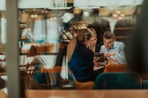 contento uomini d'affari sorridente allegramente durante un' incontro nel un' caffè negozio. gruppo di riuscito attività commerciale professionisti Lavorando come un' squadra nel un' multiculturale posto di lavoro. foto