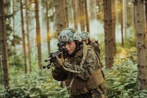 un' gruppo di moderno guerra soldati è combattente un' guerra nel pericoloso a distanza foresta le zone. un' gruppo di soldati è combattente su il nemico linea con moderno Armi. il concetto di guerra e militare conflitti foto