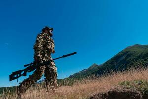 esercito soldato Tenere un' cecchino fucile con scopo e a piedi nel il foresta. guerra, esercito, tecnologia e persone concetto. foto