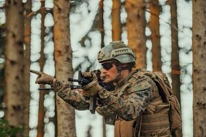 moderno guerra soldato ufficiale è mostrando tattico mano segnali per silenziosamente dare ordini e alers per squadra squadra foresta ambiente foto