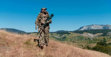 esercito soldato Tenere un' cecchino fucile con scopo e a piedi nel il foresta. guerra, esercito, tecnologia e persone concetto. foto