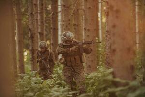 un' gruppo di moderno guerra soldati è combattente un' guerra nel pericoloso a distanza foresta le zone. un' gruppo di soldati è combattente su il nemico linea con moderno Armi. il concetto di guerra e militare conflitti foto