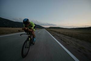 atleta di triathlon in bicicletta di notte foto