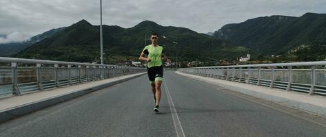 atleta di triathlon che corre su strada foto