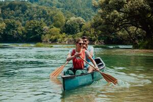 coppia avventuroso esploratore amici siamo canoa nel un' selvaggio fiume circondato di il bellissimo natura foto