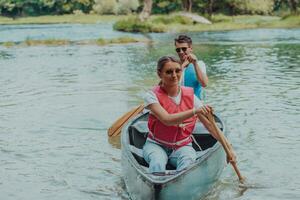 coppia avventuroso esploratore amici siamo canoa nel un' selvaggio fiume circondato di il bellissimo natura foto