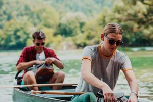 coppia avventuroso esploratore amici siamo canoa nel un' selvaggio fiume circondato di il bellissimo natura foto