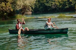 coppia avventuroso esploratore amici siamo canoa nel un' selvaggio fiume circondato di il bellissimo natura foto